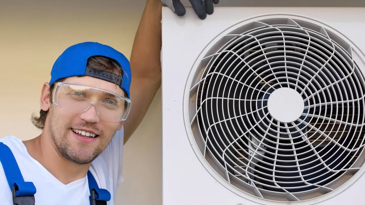 Satisfied master installer smile camera after mounting outdoor conditioning unit