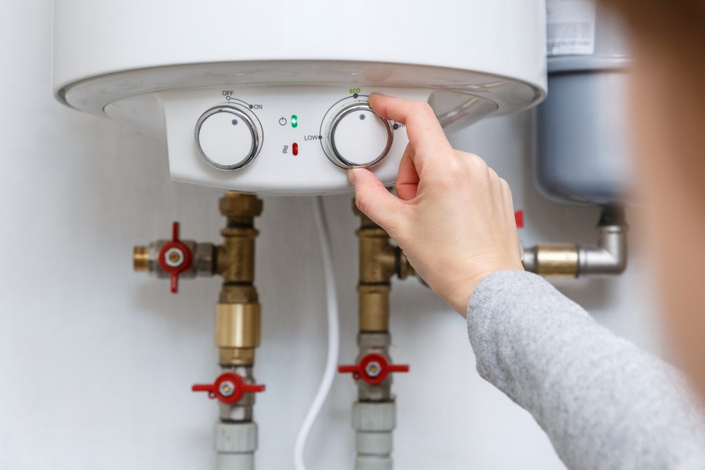 Female hand on electric water heater 